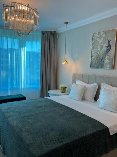 a bedroom with a large bed with a chandelier at Vila DLK in Mamaia Sat/Năvodari