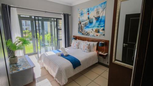 a bedroom with a bed and a large window at 7 Topanga in Uvongo Beach