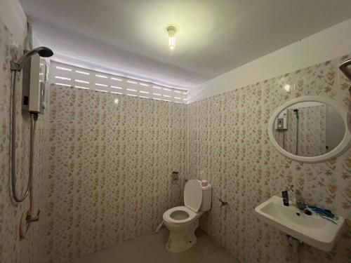 a bathroom with a toilet and a sink and a mirror at Honey Zen Zone in Ko Mak