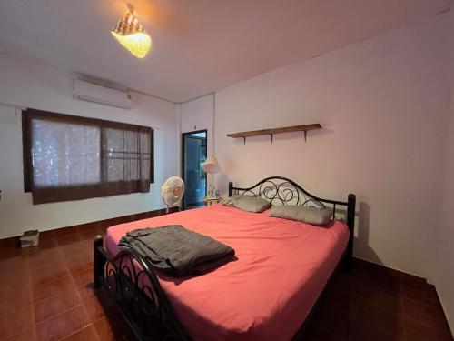 a bedroom with a bed with red sheets and a window at Honey Zen Zone in Ko Mak