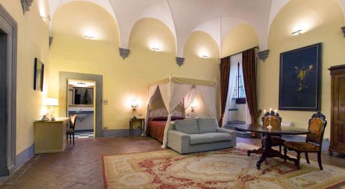 uma sala de estar com uma cama, um sofá e uma mesa em Villa Il Fedino em San Casciano in Val di Pesa