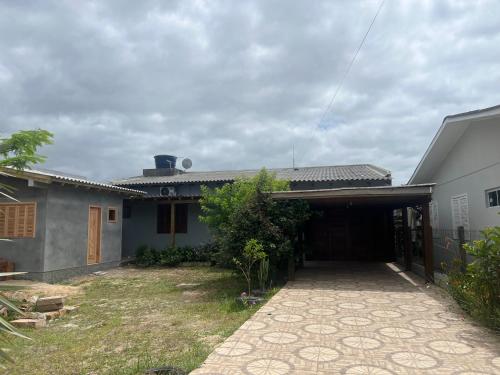 a house with a driveway leading to a garage at Residência Rosalaura in Balneário Gaivotas