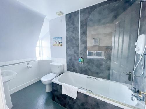 a bathroom with a tub and a toilet and a shower at Cullen Bay Hotel in Cullen