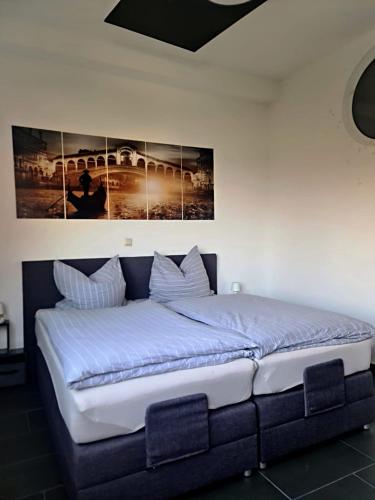 a large bed in a bedroom with two pictures on the wall at Casa Mia in Goslar