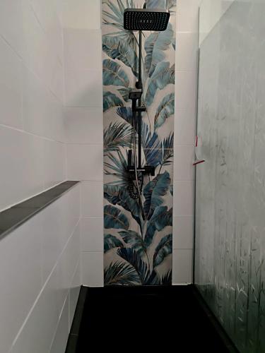 a shower in a bathroom with a mural of leaves at Casa Mia in Goslar