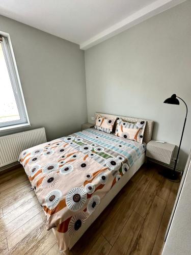a bedroom with a bed with a comforter and pillows at DB Guest House 2 in Târgu Secuiesc