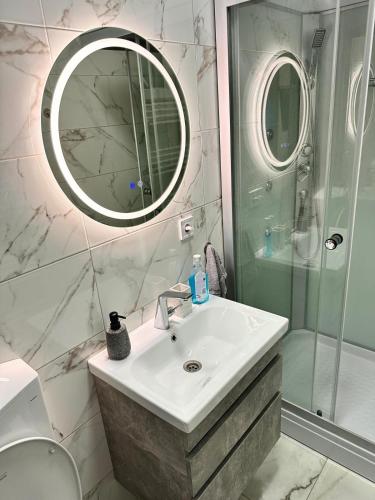 a bathroom with a sink and a shower and a mirror at DB Guest House 2 in Târgu Secuiesc