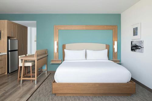 a bedroom with a large white bed and a desk at Element by Marriott Opelika Auburn in Opelika