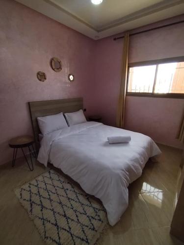 a bedroom with a large white bed and a window at Nomad Surf Morocco in Imsouane