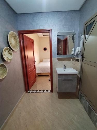 a bathroom with a sink and a bathroom with a bed at Nomad Surf Morocco in Imsouane
