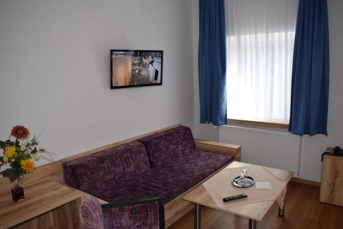 a living room with a couch and a table at Hotel Seeschlösschen in Groß Köris