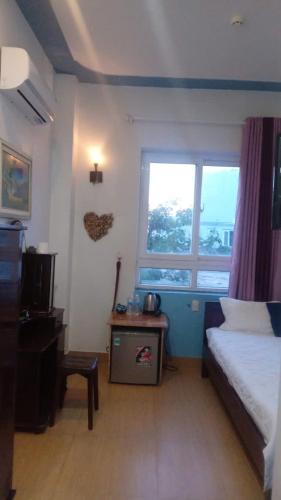 a small bedroom with a bed and a window at Thanh Tran Guesthouse Lý Sơn in Ly Son