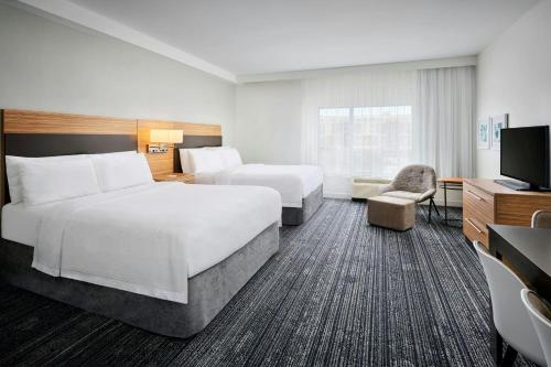 a hotel room with two beds and a flat screen tv at TownePlace Suites by Marriott Ottawa Kanata in Ottawa