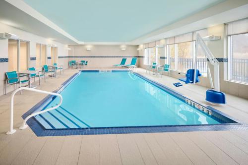 a large pool with blue chairs and tables in a building at TownePlace Suites by Marriott Ottawa Kanata in Ottawa