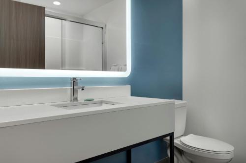 a bathroom with a sink and a toilet and a mirror at StudioRes by Marriott Oak Ridge in Oak Ridge