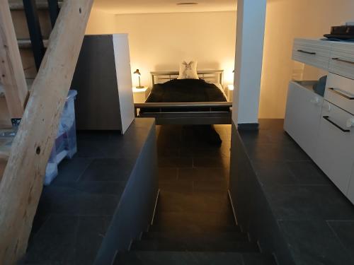 a bedroom with a bed and a staircase in it at FeWo Eriswil by R&B in Eriswil