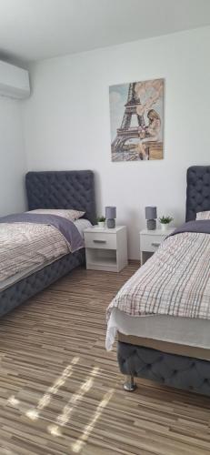 two beds in a bedroom with the eiffel tower at Vila Marjanovic PN in Paraćin