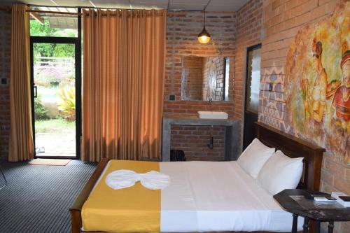 a bedroom with a bed with a bow tie on it at Elephant Arcade Yala in Tissamaharama