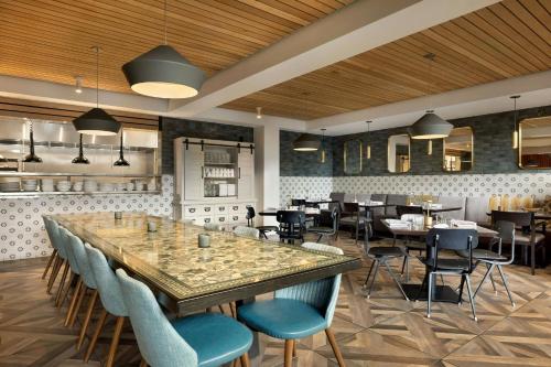 a restaurant with a large table and chairs at The Casso, Raleigh, a Tribute Portfolio Hotel in Raleigh
