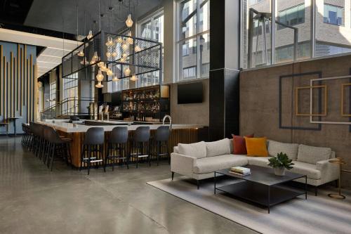 a lobby with a bar with a couch and a table at The Casso, Raleigh, a Tribute Portfolio Hotel in Raleigh