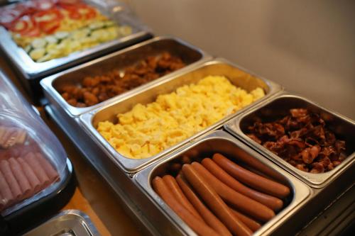a buffet with trays of different types of food at Bazilika alatt Panzió in Esztergom
