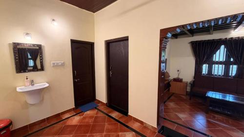 a hallway with two doors and a sink in a room at Coastal Hideout Family Cottages Malpe Beach in Malpe