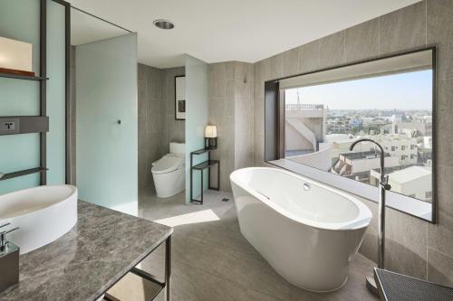 a bathroom with a white tub and a window at Yong Le Lukang, a Tribute Portfolio Hotel in Lukang