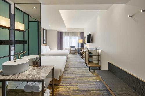 a hotel room with a bathroom with a sink at Yong Le Lukang, a Tribute Portfolio Hotel in Lukang