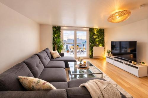 a living room with a couch and a large tv at Penthouse 166 m2- Terrasse & Parking - Paris Sud - Orly - Parc Expo in Bagneux