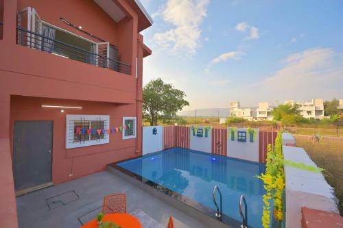 a house with a swimming pool in front of it at ll EMPYREAN STAY ll THE LOVE SHAKE ll 2BHK ll AC ll PRIVATE POOL ll BACHELORS FRIENDLY ll in Malavli