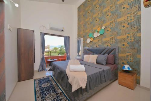 a bedroom with a bed and a wall at ll EMPYREAN STAY ll THE LOVE SHAKE ll 2BHK ll AC ll PRIVATE POOL ll BACHELORS FRIENDLY ll in Malavli