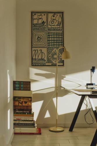 a lamp in a room with books and a desk at Thomas House on Train Tracks in Mestre