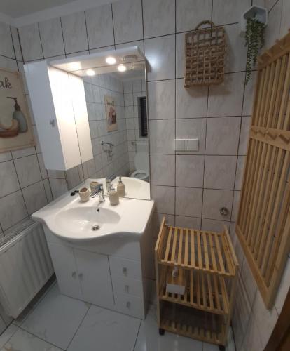 a white bathroom with a sink and a mirror at Pauza Plac in Žitence