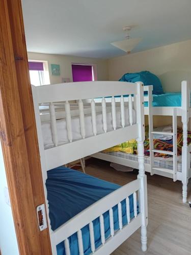 two white bunk beds in a room at An Tigín, Gortadoo in Dingle