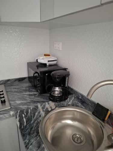 een keukenblad met een spoelbak en een koffiezetapparaat bij Casa do Céu Azul in Tarrafal