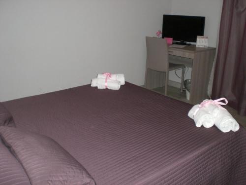 1 dormitorio con 1 cama con zapatillas y escritorio en Apartment Flat Fiumicino, en Fiumicino
