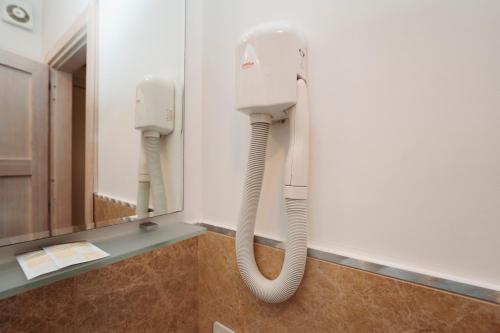 a white phone hanging on a wall next to a mirror at Hotel Di Nardo in Petacciato