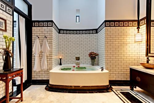 ein großes Badezimmer mit Badewanne in einem Zimmer in der Unterkunft The Siam in Bangkok