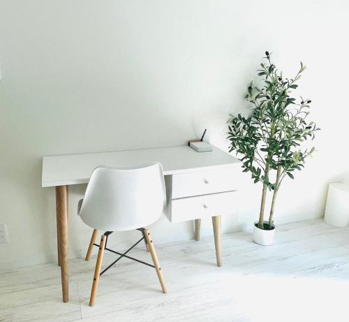 a white desk with a chair and a plant at Sunny Inn Sumida in Tokyo