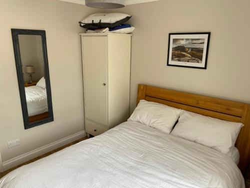 a bedroom with a white bed and a mirror at Lough Álainn - Tourism NI Certified in Warrenpoint