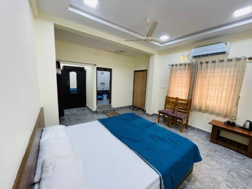 a bedroom with a large bed and a desk at RK Comforts in Belūr