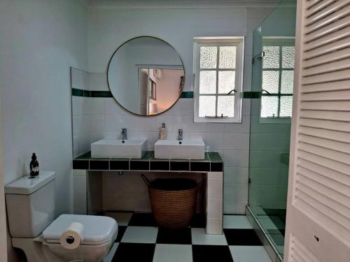 a bathroom with two sinks and a mirror at Sensitively restored spacious apartment in Durban