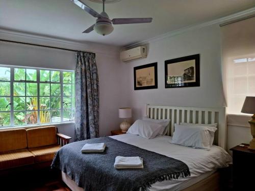 a bedroom with a bed with two towels on it at Sensitively restored spacious apartment in Durban