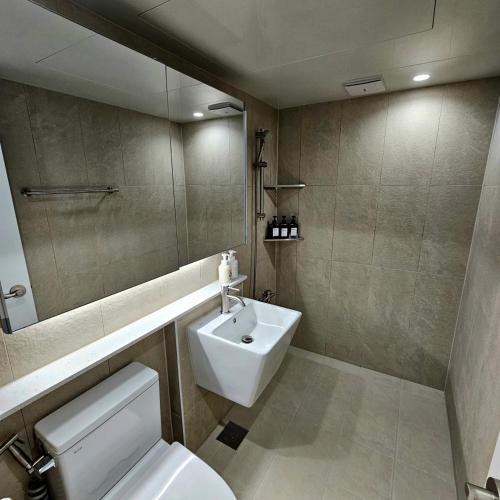 a bathroom with a sink and a toilet and a mirror at Ocean House PH in Pohang