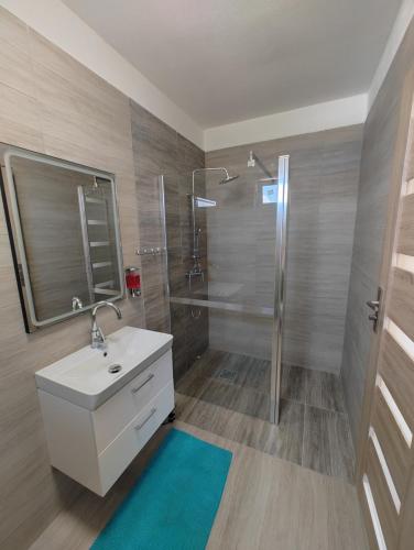 a bathroom with a white sink and a shower at Pohoda Stay in Revúca