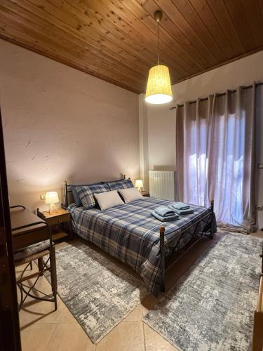 a bedroom with a bed and a table and a lamp at Septem Mountain House in Eptalofos