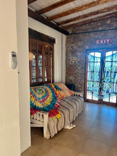 a bedroom with a bed with a colorful blanket on it at GinTonic Rancho in San Luis