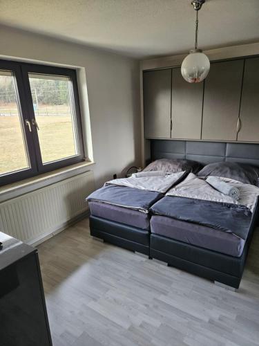 a bedroom with a bed and a large window at Ferienhaus Petzenblick - ganzjährig beheizter und privater Indoorpool in Konovece