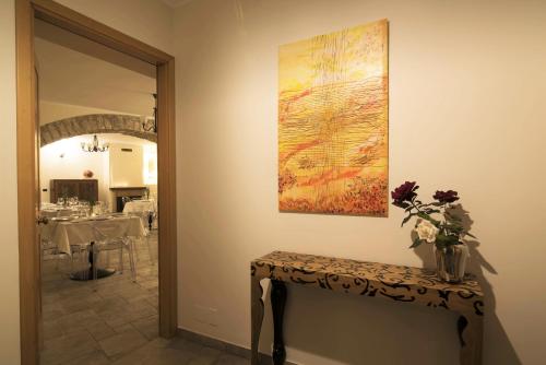 a painting on the wall next to a table with flowers at BBuSS Country Club in Catanzaro