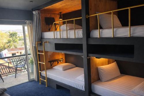 a bunk bed room with four bunk beds and a balcony at Free Way Kata Beach Hostel in Kata Beach